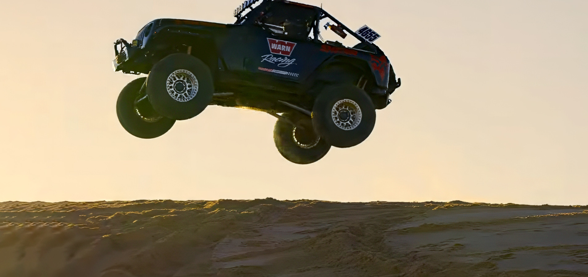 Race Jeep on SHOWA shocks airborne at sunset